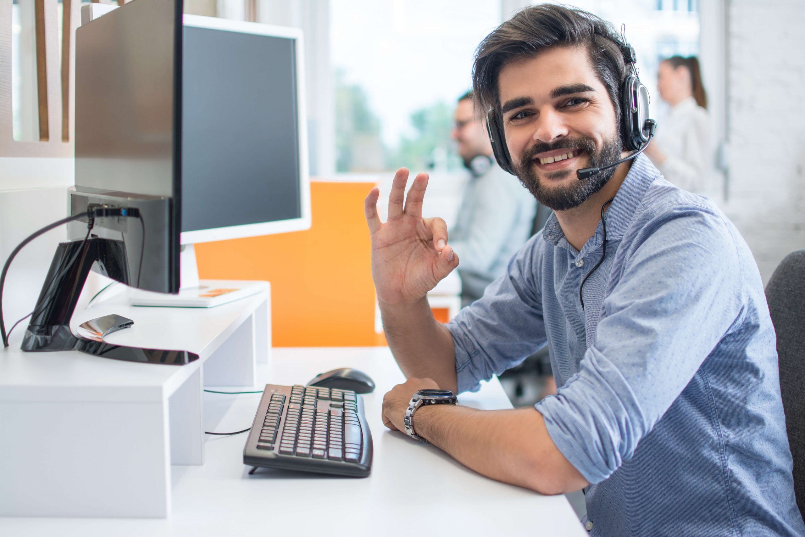 man with headset on sat at desk