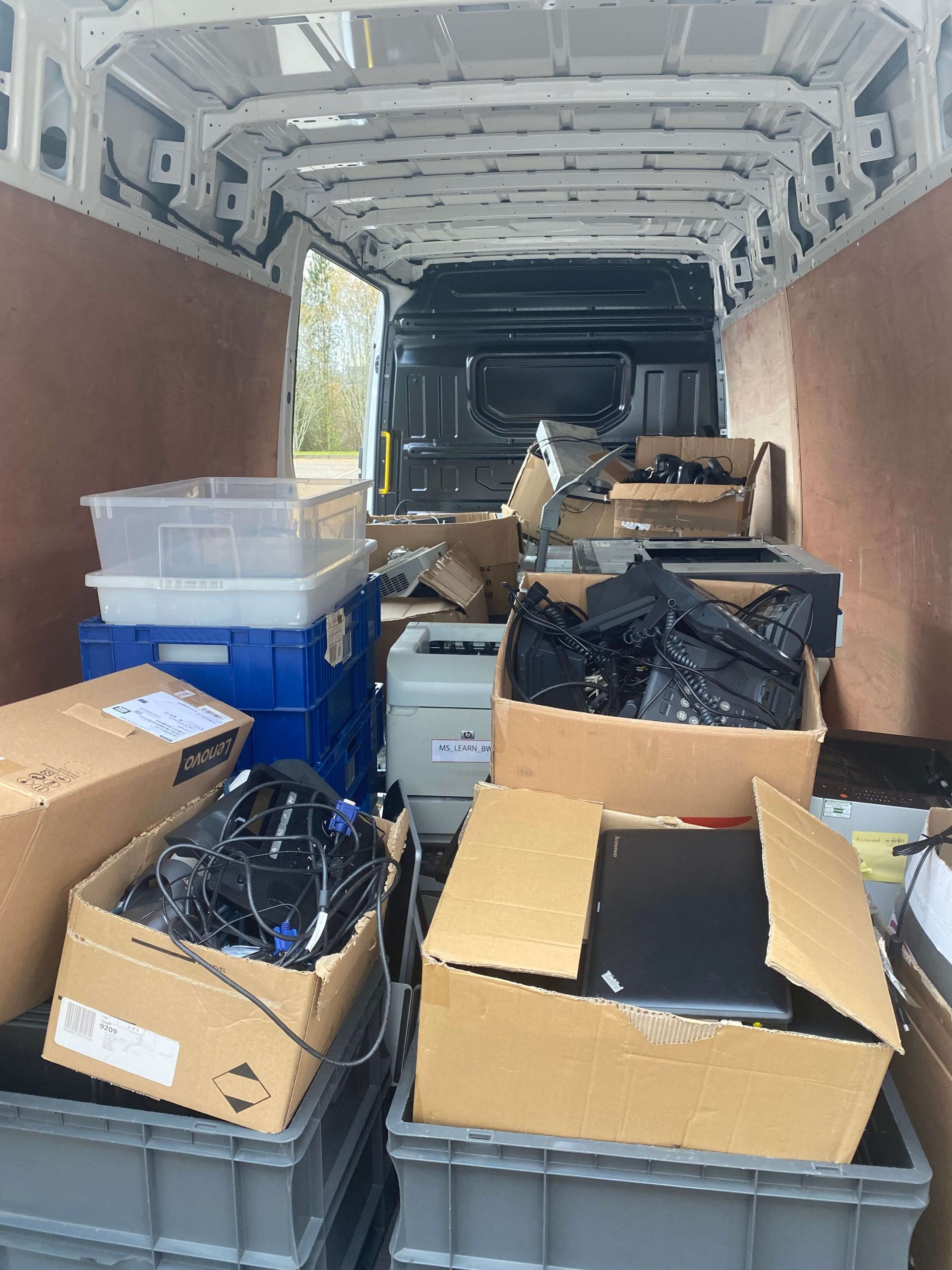 van filled with unused tech in cardboard boxes