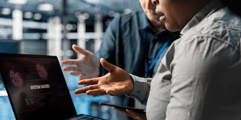 People pointing to cyber threat on laptop